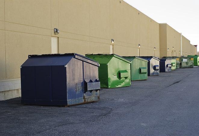 a compact construction dumpster being emptied by a waste disposal truck in Cocoa